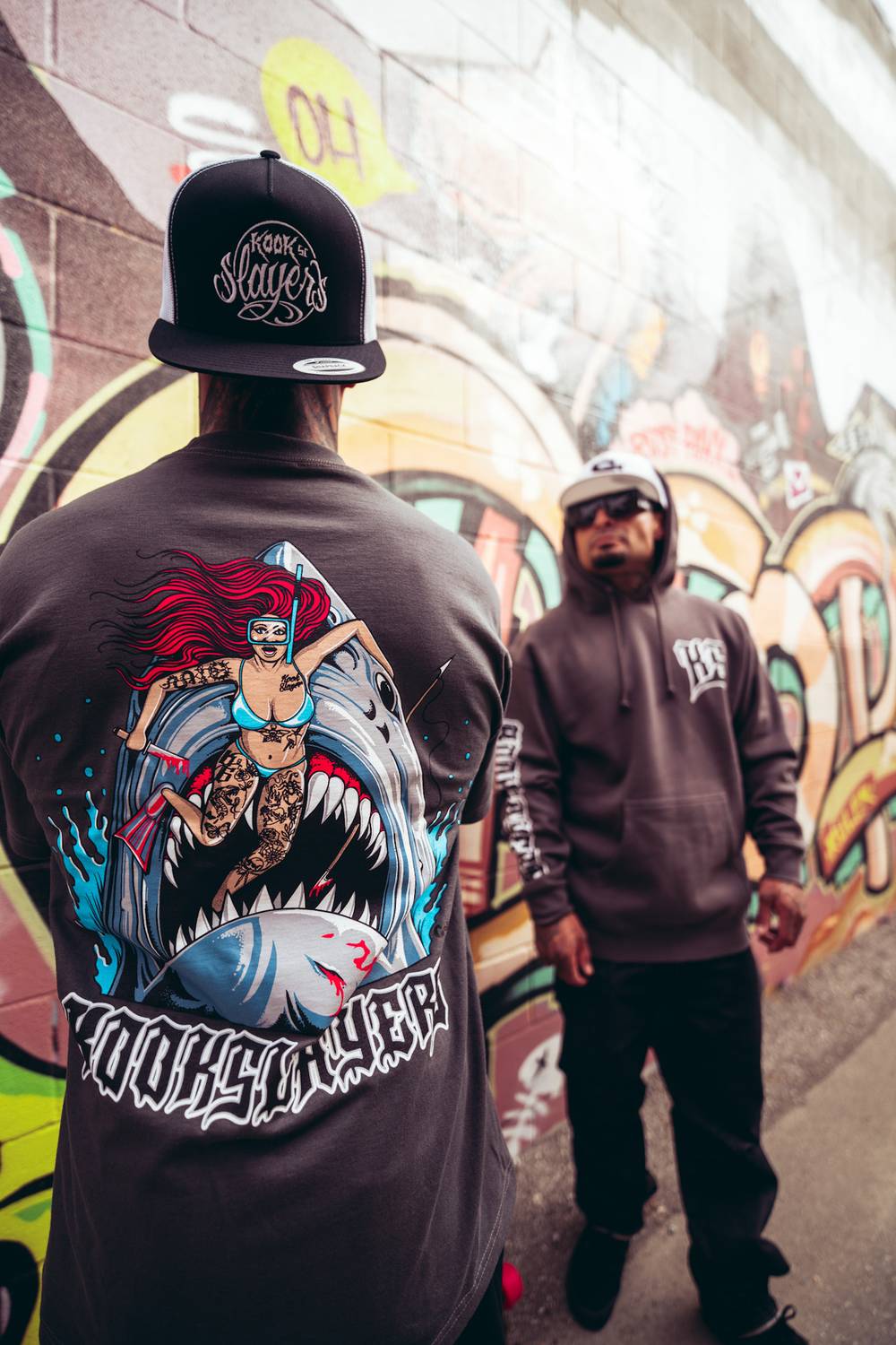 Back of the Colby Phillips Shark Tee in front of the Kook Town mural